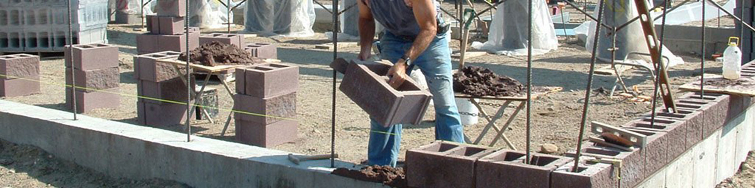 guy laying concrete blocks in building foundation