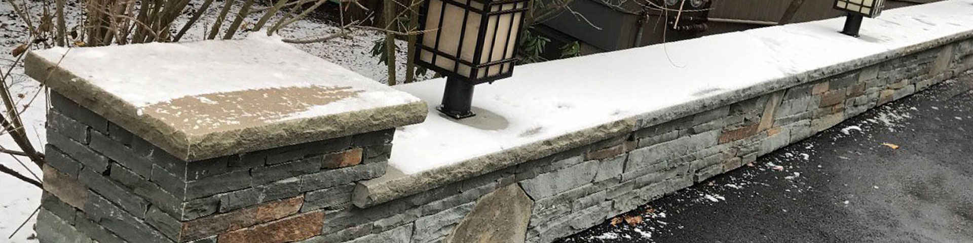 natural stone landscaping wall with snow on it